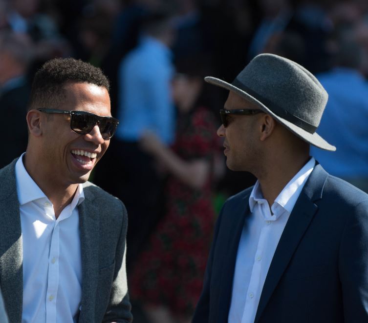 Two men in suits enjoying themselves at the grand national festival