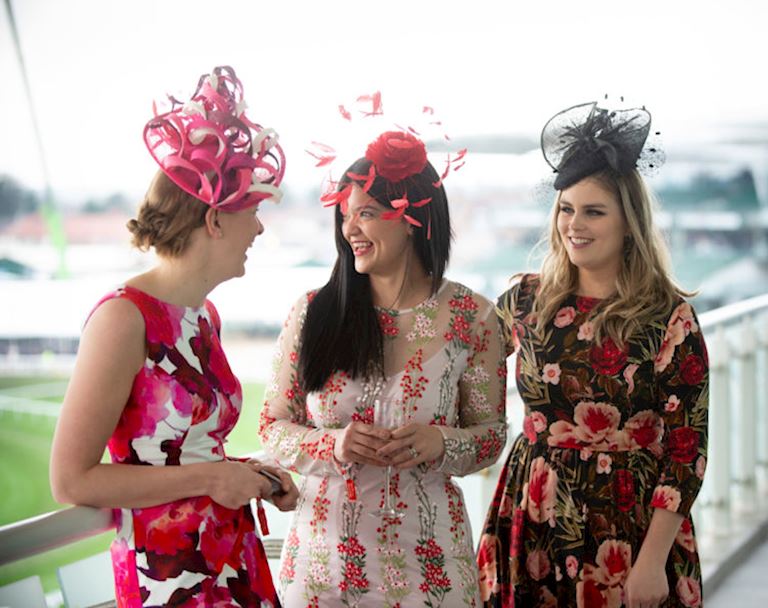 women dressed in floral dresses watching racing
